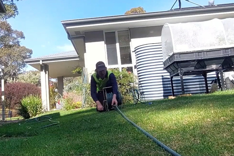 Wrapping up a demanding day`s work, the nowra downpipe cleaner is coiling up his hose.